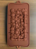 A rectangular brown chocolate bar mould with a bubble pattern.